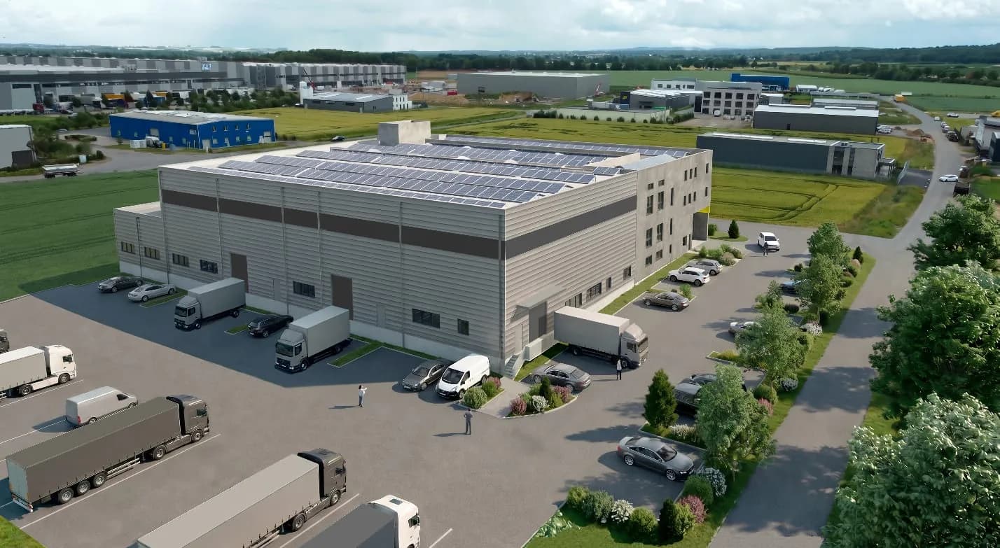 Visualisierung des Neubaus aus der Luft: Halle mit Verladehof, Lkw an den Rampen, Photovoltaik auf dem Dach und Bürotrakt